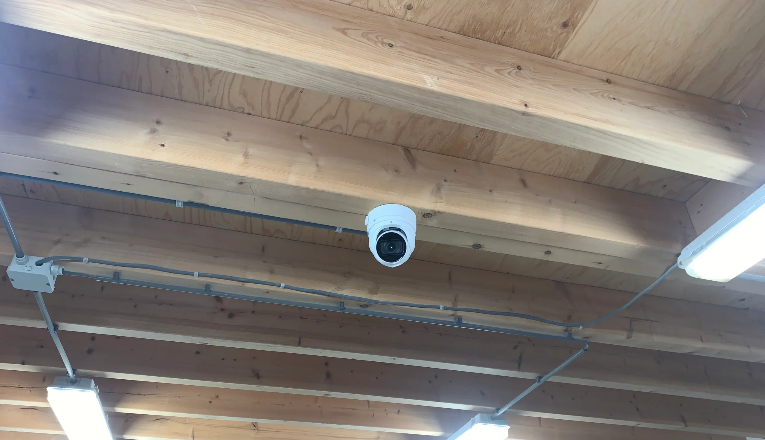 Discrete dome-camera op het houten plafond van de bakkerij